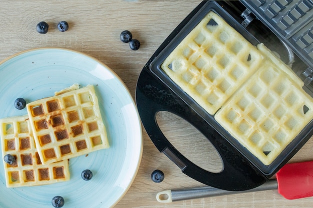 Foto waffles al horno en la máquina para hacer gofres. gofres salados. concepto de desayuno