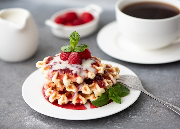 Waffles con almíbar, frambuesas y hojas de menta