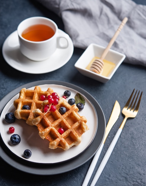 Waffles belgas con bayas, miel y té