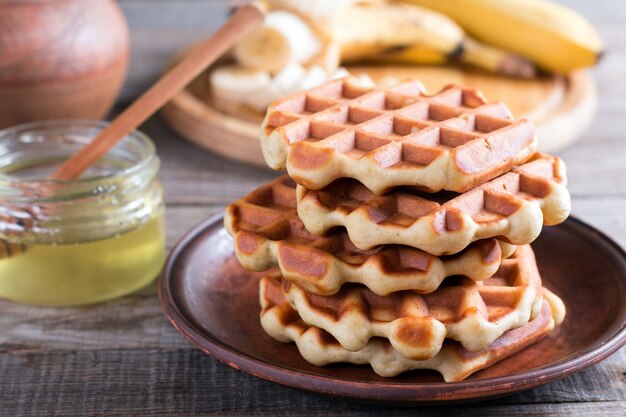 Waffles belgas caseros con plátanos y miel en un plato