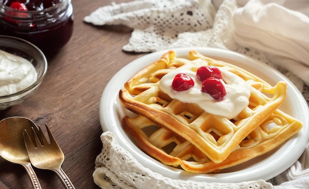 Foto waffles belgas com creme de leite e geleia de cereja