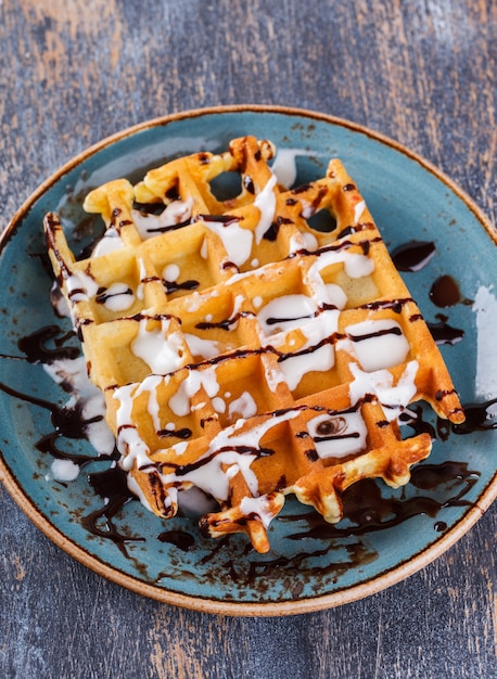 Waffles belgas com frutas frescas e molho de chocolate.