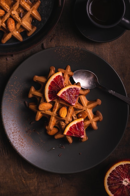 Waffles belgas com laranja em um prato, flat lay