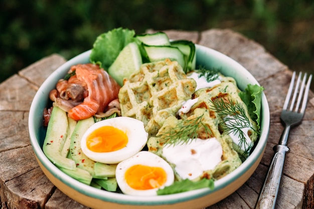 Waffles belgas com salmão, abacate e ovo em um prato