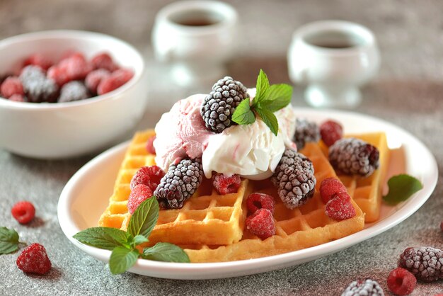 Waffles belgas com sorvete, hortelã, framboesas congeladas e amoras