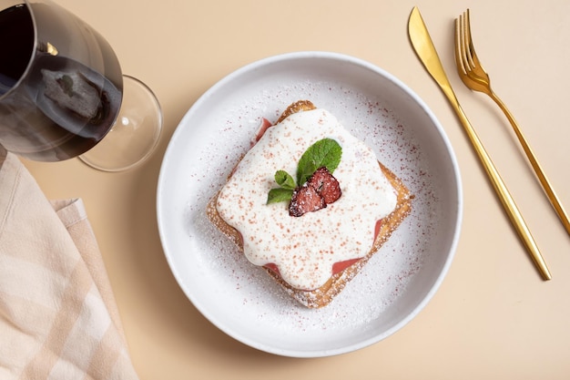 Waffles belgas con confit de fresa y salsa de crema sobre un fondo beige