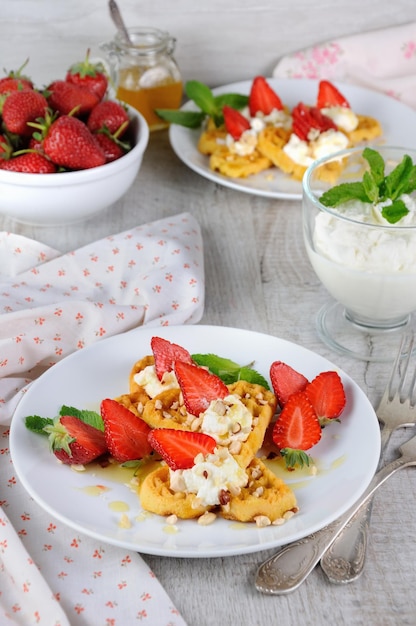 Waffles belgas con crema batida de fresas aromatizadas con cacahuetes y miel