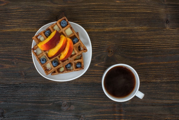 Waffles belgas de chocolate com frutas e café. Delicioso café da manhã. Vista do topo