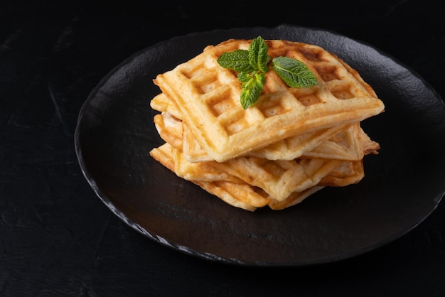 Waffles belgas deliciosos caseiros na mesa preta