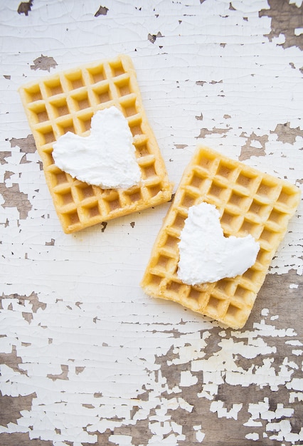 Waffles belgas muito bonitos sobre uma mesa velha.