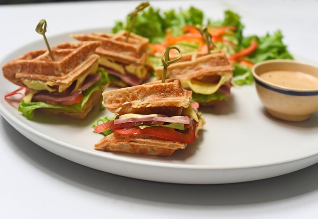 Waffles belgas en un plato blanco con verduras de cerca