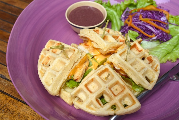 Waffles belgas con pollo frito en plato morado