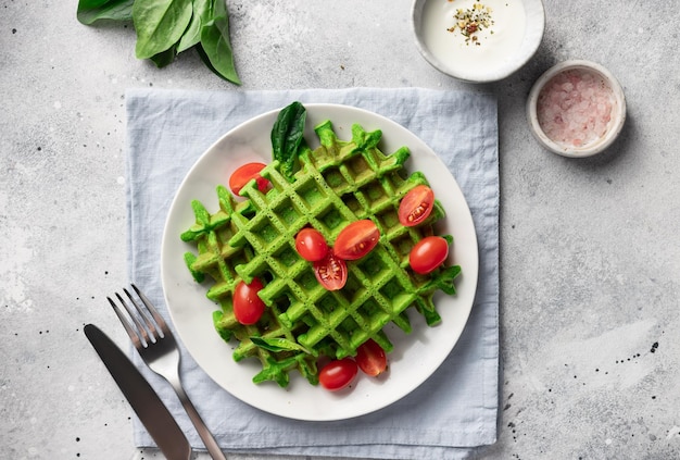 Waffles belgas salados con espinacas en un plato blanco