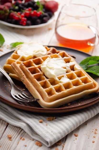 Waffles belgas servidos con mantequilla y miel