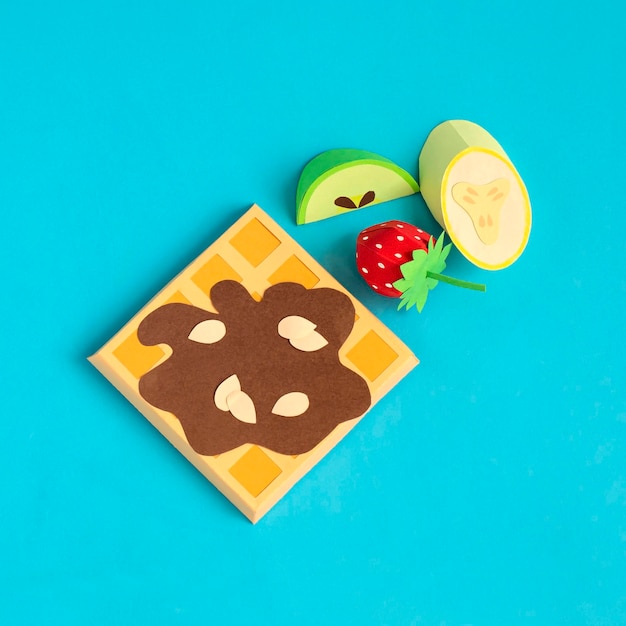 Waffles belgas con sirope de chocolate y trozos de fruta de papel