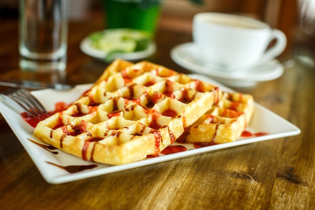 Waffles y café en la mesa de madera