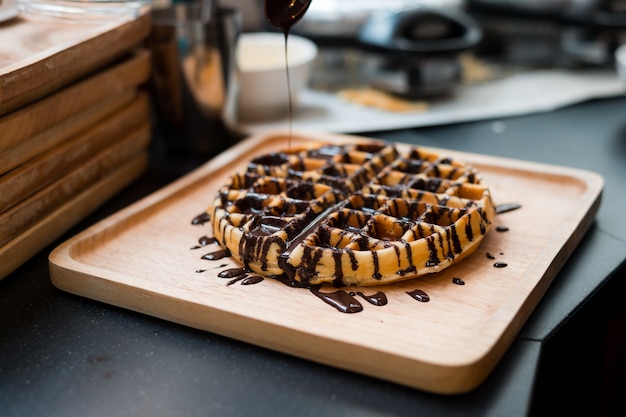 Waffles com calda de chocolate na chapa de madeira