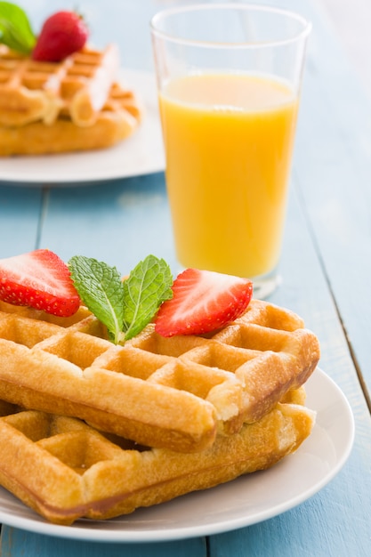 Waffles com morango na mesa de madeira azul