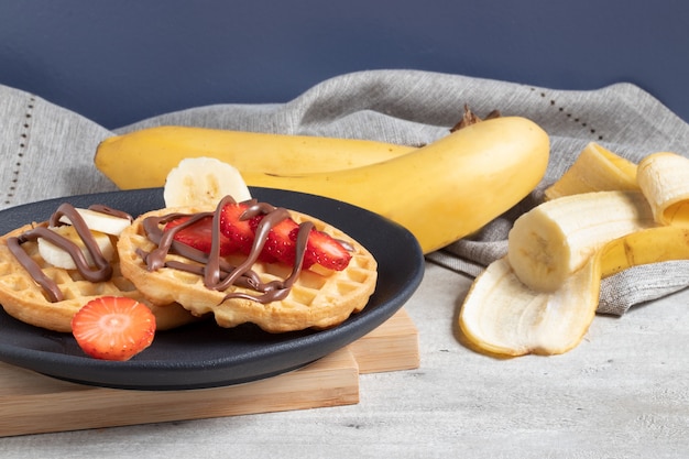 Waffles combinados con plátano y fresa.