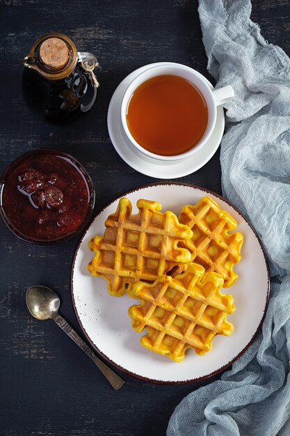 Waffles de abóbora doce com geléia de morango. delicioso café da manhã com waffles belgas. vista do topo