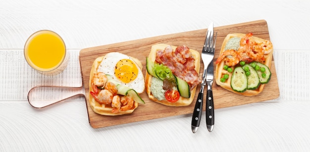 Waffles de café da manhã com ovos fritos salmão pepino e camarões