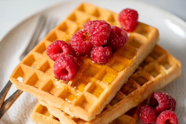 Waffles de closeup com frutas no prato servido com xícara de chá