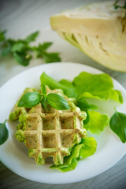 Waffles de vegetais cozidos com ervas em um prato em uma mesa de madeira