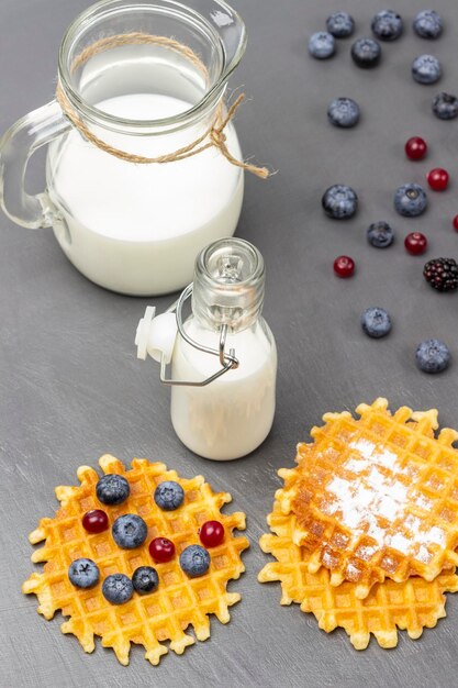 Waffles e frutas na mesa Leite em garrafa de vidro e jarro