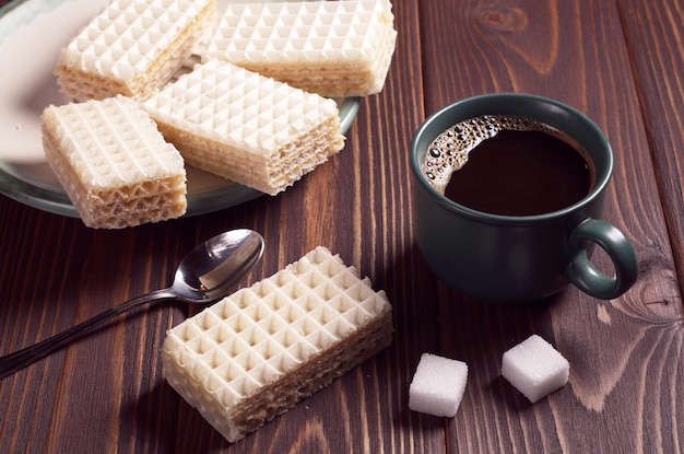 Waffles e xícara de café quente no café da manhã na mesa de madeira marrom