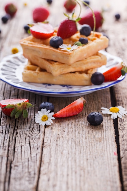 Waffles con fresas y arándanos para el desayuno, belga.