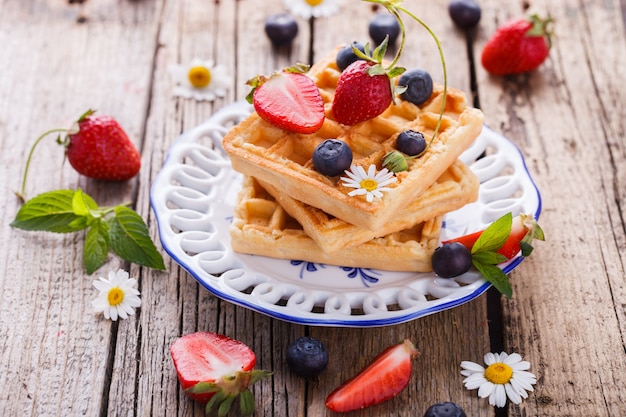 Waffles con fresas y arándanos para el desayuno, belga.