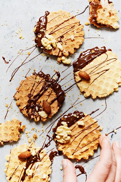 Waffles holandeses com caramelo salgado, nozes e chocolate preto sobre um fundo cinza