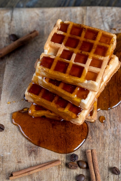 Waffles macios com mel de abelha natural em uma tábua de servir