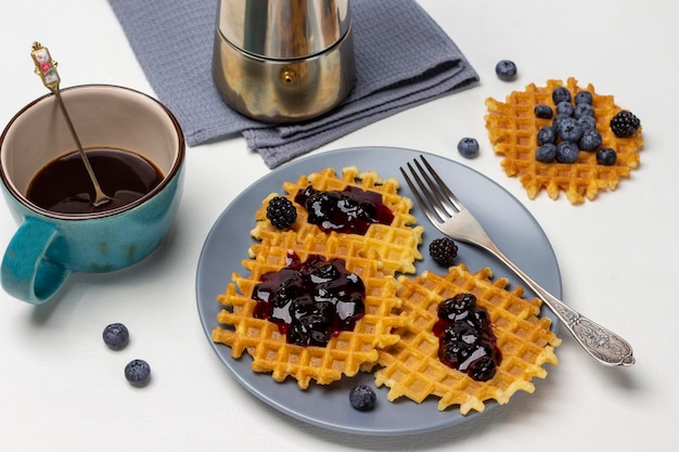 Waffles con mermelada y tenedor en plato gris