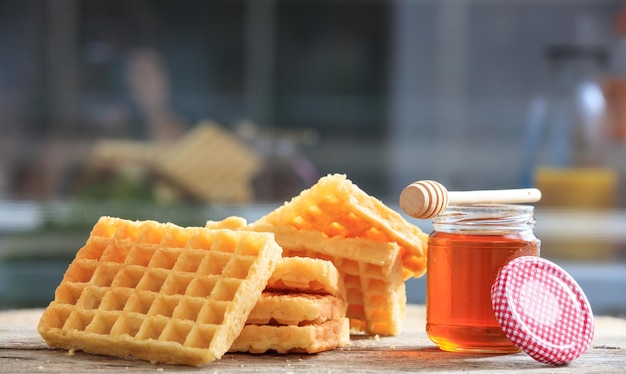 Waffles y miel en una mesa de madera