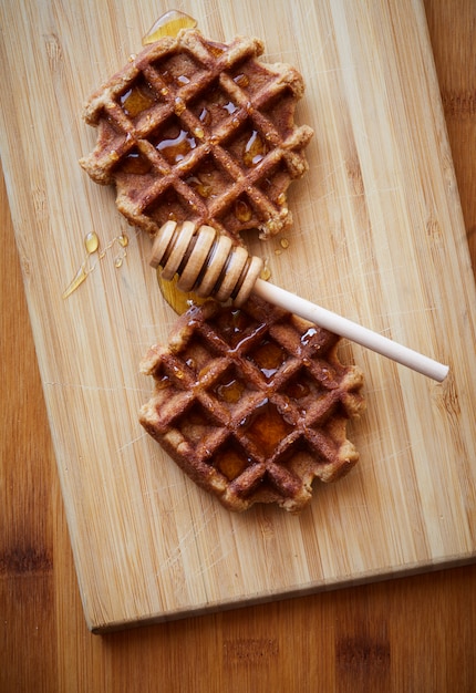Waffles con miel en plato de madera