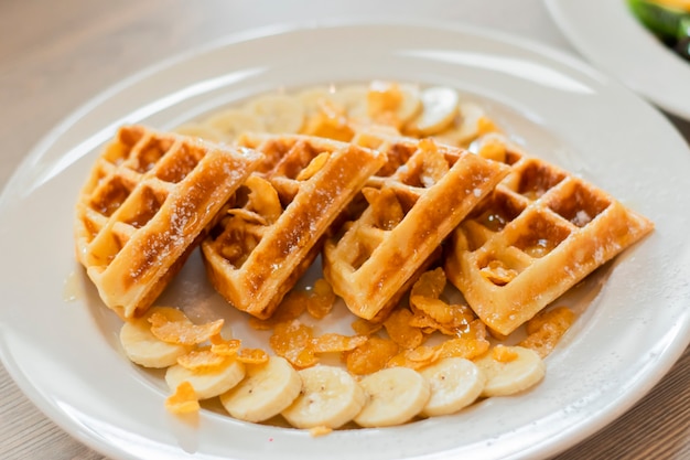 Waffles en un plato, con salsa de plátano y caramelo.