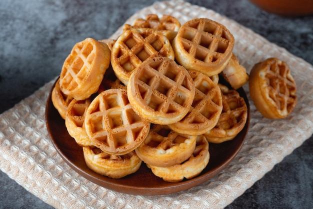 Waffles redondos horneados en placa sobre fondo gris