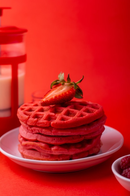 waffles vermelhos saudáveis com frutas mel e leite no fundo vermelho com ângulos diferentes