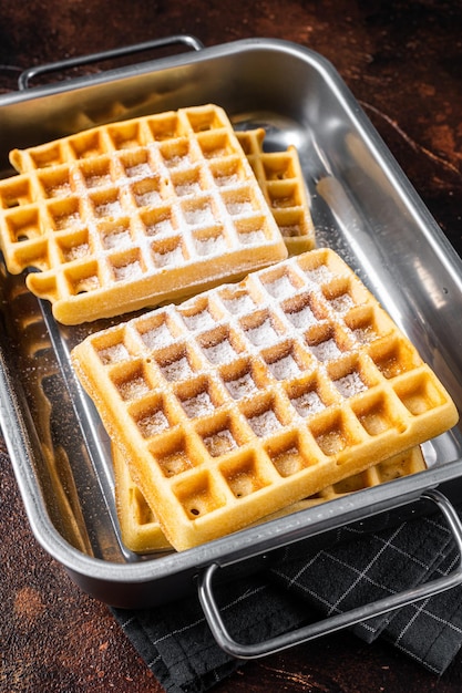 Waffles vienenses com açúcar em pó na bandeja de aço da cozinha Fundo escuro Vista superior