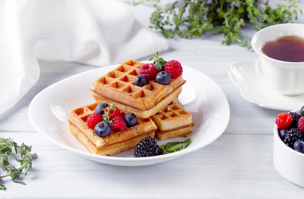 Waffles vienenses com frutas vermelhas em uma mesa branca café da manhã sem pessoas na horizontal