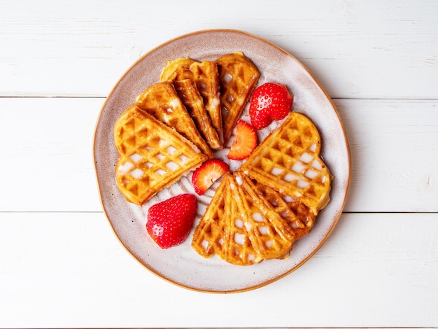 Waffles vieneses recién horneados espolvoreados con azúcar en polvo sobre un plato de cerámica negra