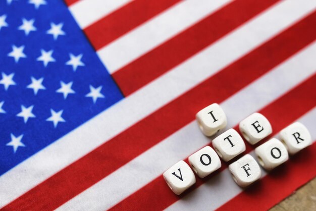 Foto wahl-simbol auf usa-flagge mit buchstabenholzwürfeln