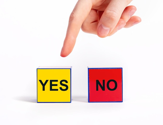 Wahl zwischen Würfeln mit Ja- und Nein-Konzept Auswahl zwischen positiven und negativen Entscheidungen Zeigefinger zeigt auf Block