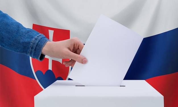 Wahlen in der Slowakei Wahlkonzept Eine Hand wirft einen Stimmzettel in die Stimmurne Flagge der Slowakie