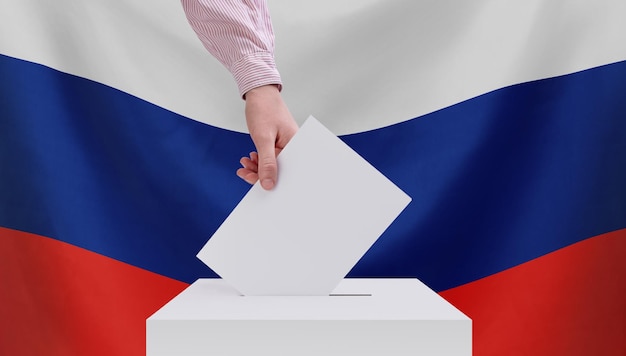 Wahlen in Russland Das Konzept der Wahlen Eine Hand wirft einen Stimmzettel in die Wahlurne Russische Flagge