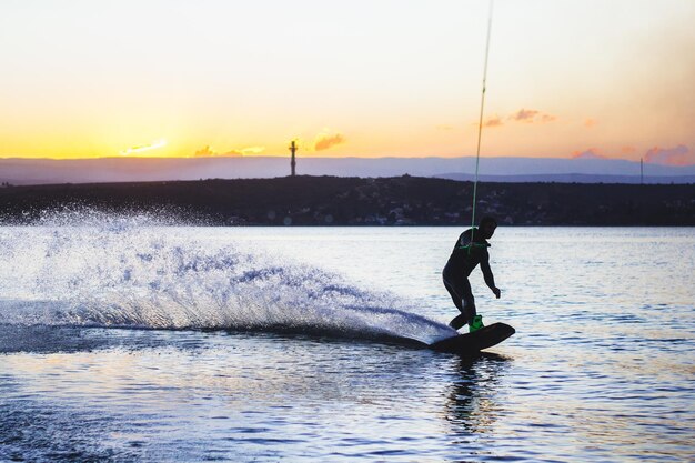 Foto wakeboarding-mann gegen den sonnenuntergang