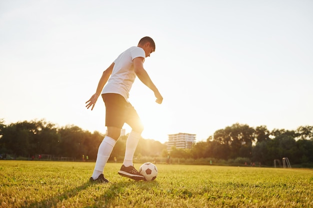 Wald im Hintergrund Junge Fußballspieler trainieren auf dem sportlichen Feld