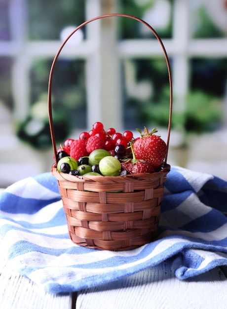 Waldbeeren im Weidenkorb auf Holztisch auf hellem Hintergrund