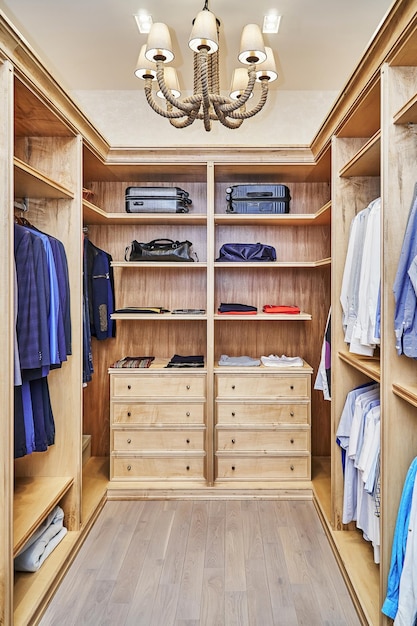 Walk-in closet con muebles de madera maciza de arce y chapada para guardar ropa con moldura de corona